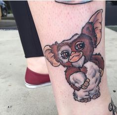 a close up of a person's leg with a small animal tattoo on it