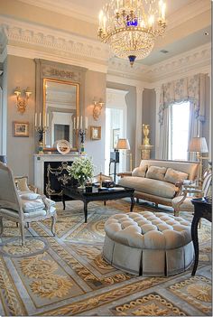 an elegant living room with chandelier and couches