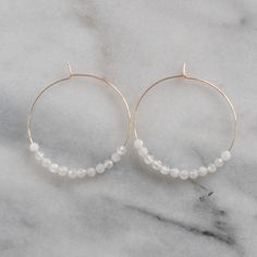 With white moonstone beads (that are said to be a feminine and sensual gemstone) these hoops will give you all the girl power vibes you need. 45mm (about 1.75") gold-filled or sterling silver hoops with White Moonstone gemstone beads packaged on a kraft earring card in a clear resealing bag gold-filled hoops are lead-free gold over brass. Gold-filled has much more gold than gold-plated and will last longer without tarnishing. Not sure which gemstone to choose? This blog post might help: Get Your Round Moonstone Hoop Earrings As A Gift, White 14k Gold Filled Hoop Earrings, White 14k Gold Filled Hoop Jewelry, Adjustable Nickel-free White Hoop Earrings, Adjustable White Nickel Free Hoop Earrings, Handmade White 14k Gold Filled Hoop Earrings, Handmade 14k Gold Filled White Hoop Earrings, White Hypoallergenic Moonstone Jewelry, Dainty White Hoop Jewelry