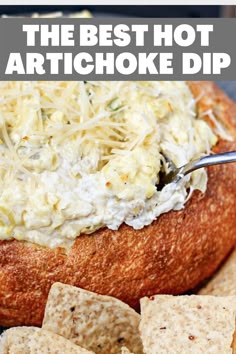 the best hot artichoke dip in a bread bowl with crackers and cheese