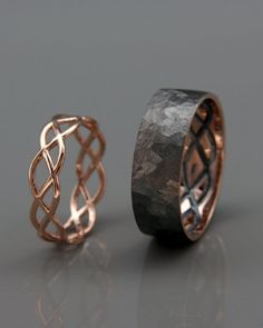 two wedding bands made out of copper and black diamond cut in to the side, one with an intricate knot design on each band