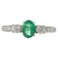 This exquisite ring features a 0.55 carat oval cut emerald, elegantly set in 18KT white gold. The emerald is complemented by 0.75 carats of round cut diamonds, with F-G color and VS1-VS2 clarity, adding exceptional brilliance and sophistication. Perfect for special occasions or everyday elegance, this ring is a luxurious and timeless addition to any jewelry collection. Emerald And Diamond Ring, Tanzanite Diamond Ring, Emerald Diamond Ring, Oval Rings, Modern Ring, Emerald Stone, Three Stone Rings, Emerald Diamond, Emerald Ring