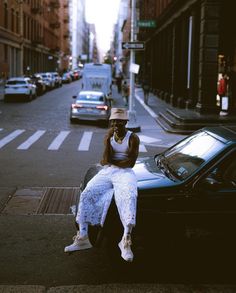 a woman sitting on the hood of a car