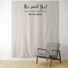 a chair sitting in front of a wall with a sign that says she said yes