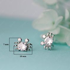 These charming crab stud earrings showcase a large cubic zirconia stone and two smaller ones set in lustrous 925 sterling silver, meticulously polished for a brilliant gleam. The addition of 18k gold or platinum plating elevates the luxurious aesthetic. Add these delightful crab stud earrings to your fine jewelry collection or gift them to a loved one. Materials: 925 sterling silver, cubic zirconiaFinish: platinum plate, rose gold plateDimensions: 0.42 x 0.28 in Jewelry Care: See more informatio Luxurious Aesthetic, Sterling Silver Stud Earrings, Silver Stud Earrings, Big Earrings, Fine Jewelry Collection, Sterling Silver Studs, Sterling Silver Earrings Studs, Silver Earrings Studs, Silver Studs