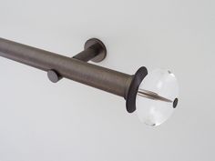 a close up of a curtain rod with a clear glass ball on the end,