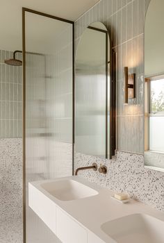 a bathroom with two sinks and a shower