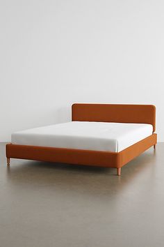 a bed with an orange headboard and foot board on the bottom half of it