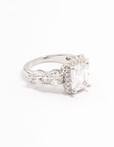 a white gold ring with an oval cut diamond surrounded by smaller round diamonds