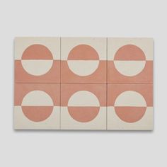 four square tiles with circles on them in pink and white, arranged against a gray background