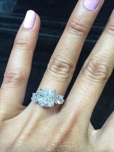 a close up of a person's hand with a diamond ring on their finger