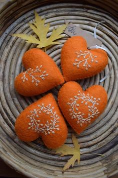 three orange hearts are sitting on a wicker basket