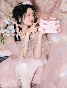 a woman sitting on the floor with a cake