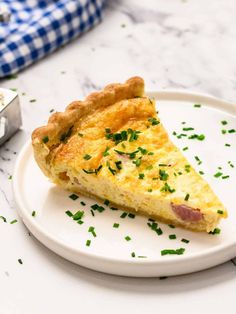 a slice of ham and cheese quiche on a plate