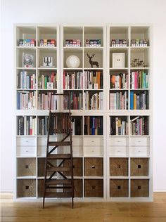 the bookshelves are filled with many different types of books and baskets in front of them