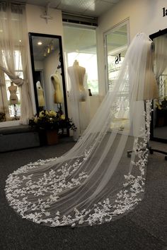 a wedding veil on display in front of mannequins