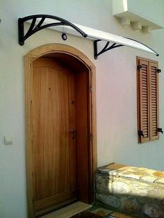 a surfboard mounted to the side of a white wall next to a wooden door