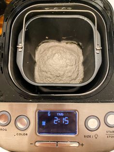 a toaster oven with a ball of bread in the front and an alarm clock on the side