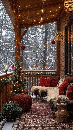 a porch covered in christmas lights and decorated for the holiday season with red pillows, rugs and decorations