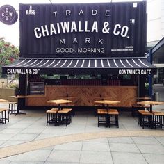 the outside of a restaurant with tables and benches