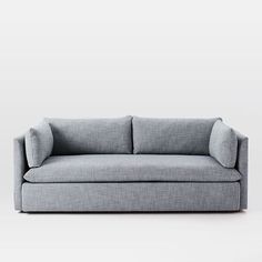 a gray couch sitting on top of a white floor