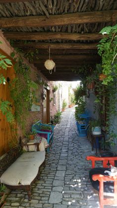 an alley way with benches, tables and plants