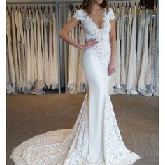 a woman standing in front of a rack of wedding gowns on her phone screen