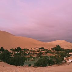 the desert is filled with sand dunes and small water pools, as well as houses