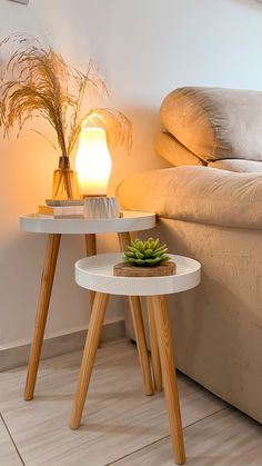 two tables with plants on them near a bed