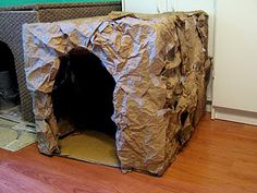 a dog house made out of cardboard sitting on the floor