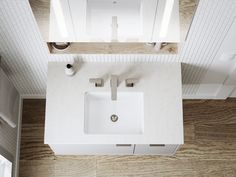 an overhead view of a bathroom sink and countertop with wood flooring in the background