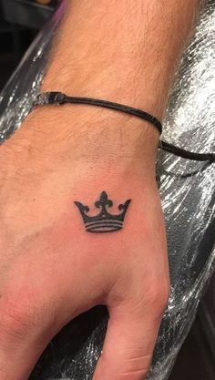 a hand with a crown tattoo on it