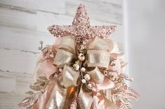 a pink and gold christmas ornament hanging on a wall