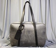 "Elevate your travel style with our exquisite Handcrafted Leather Travel Overnight Bag a fusion of elegance, durability, and wanderlust. This leather bag has a unique style of long handles that make this bag more stylish and easy to carry. LEATHER COLOUR: GRAY CERATO Size: 18\"x12\"x6\"(LxHxW) FREE Personalization on the Leather tag. Key Features: Our artisans handcraft each travel bag with precision and care, resulting in a masterpiece that stands the test of time. Every stitch is a testament t Modern Travel Briefcase With Waxed Finish, Modern Waxed Finish Briefcase For Travel, Rectangular Weekender Bag With Waxed Finish For Everyday Use, Modern Waxed Finish Satchel For Travel, Rectangular Leather Weekender Bag With Waxed Finish, Rectangular Luggage With Leather Lining For Everyday Use, Leather Rectangular Weekender Bag For Travel, Rectangular Leather Travel Bag With Waxed Finish, Rectangular Business Travel Bag With Waxed Finish