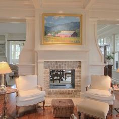 a living room filled with furniture and a fire place under a painting on the wall