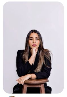 a woman sitting on top of a wooden stool