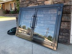 the reflection of a street light in a glass door on the sidewalk near a brick wall