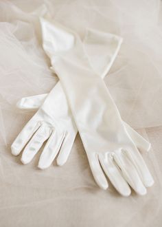 Add a touch of luxury to any simple wedding gown by adding these elegant elbow length wedding gloves. You'll look incredibly chic when you step out at your wedding in these long white gloves, which feature an elegant satin finish and a touch of stretch for a seamless fit. They're perfectly on-trend for 2024 & 2025 weddings. It doesn't matter if you're planning a chic winter wedding or a sleek, sophisticated summer soiree, these long wedding gloves will ensure your look breathtaking in photograph Chic Winter Wedding, Simple Wedding Gown, Long White Gloves, Simple Wedding Gowns, Satin Wedding Gown, Wedding Gloves, Veil Hairstyles, Bridal Gloves, Summer Soiree