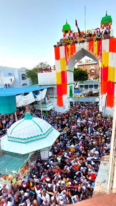 a large group of people standing in front of a building with colorful decorations on it