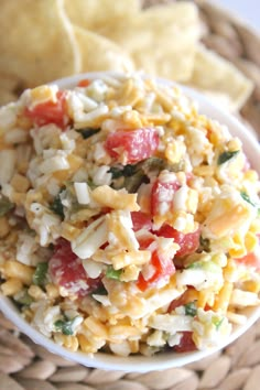 a white bowl filled with pasta salad next to tortilla chips