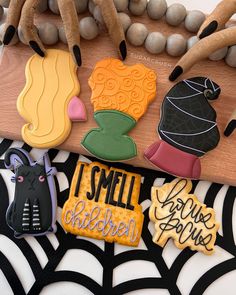 decorated cookies sitting on top of a table next to some beads and other items in the shape of witches