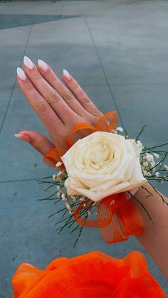 a woman's hand holding a white rose and baby's breath