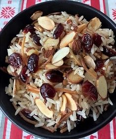 a bowl filled with rice, nuts and cranberries