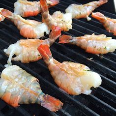 shrimp being cooked on the grill with other food items