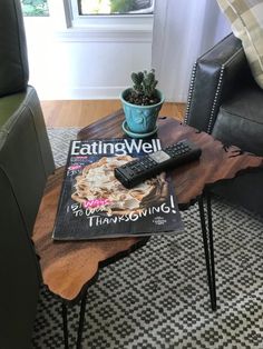 a coffee table with a magazine on it and a remote control sitting on top of it