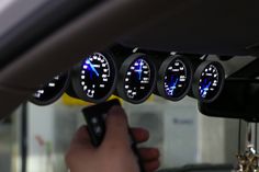 the gauges on the dashboard of a car are lit up with blue lights and white numbers