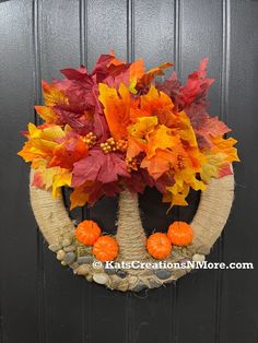 a wreath with fall leaves and pumpkins on it