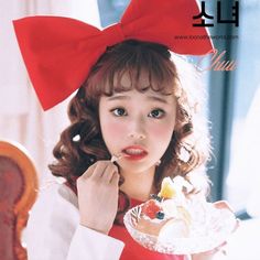 a woman with a red bow on her head eating cake