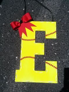 the letter e is painted yellow and has a red bow