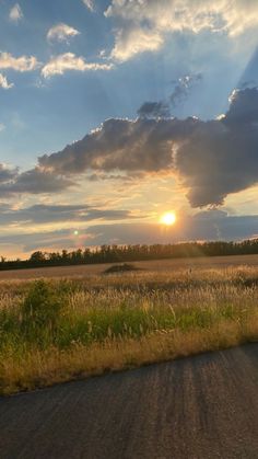 the sun is setting over an open field